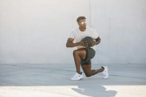 Athlete doing a fitness workout with a medicine ball on a rooftop in Austin, Texas.